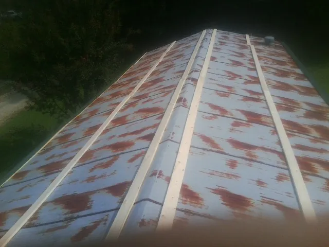 Rusted metal roof panels with new wood purlins before replacement — Storm Damage Roof Repair in Whitesburg by Roofing Brothers