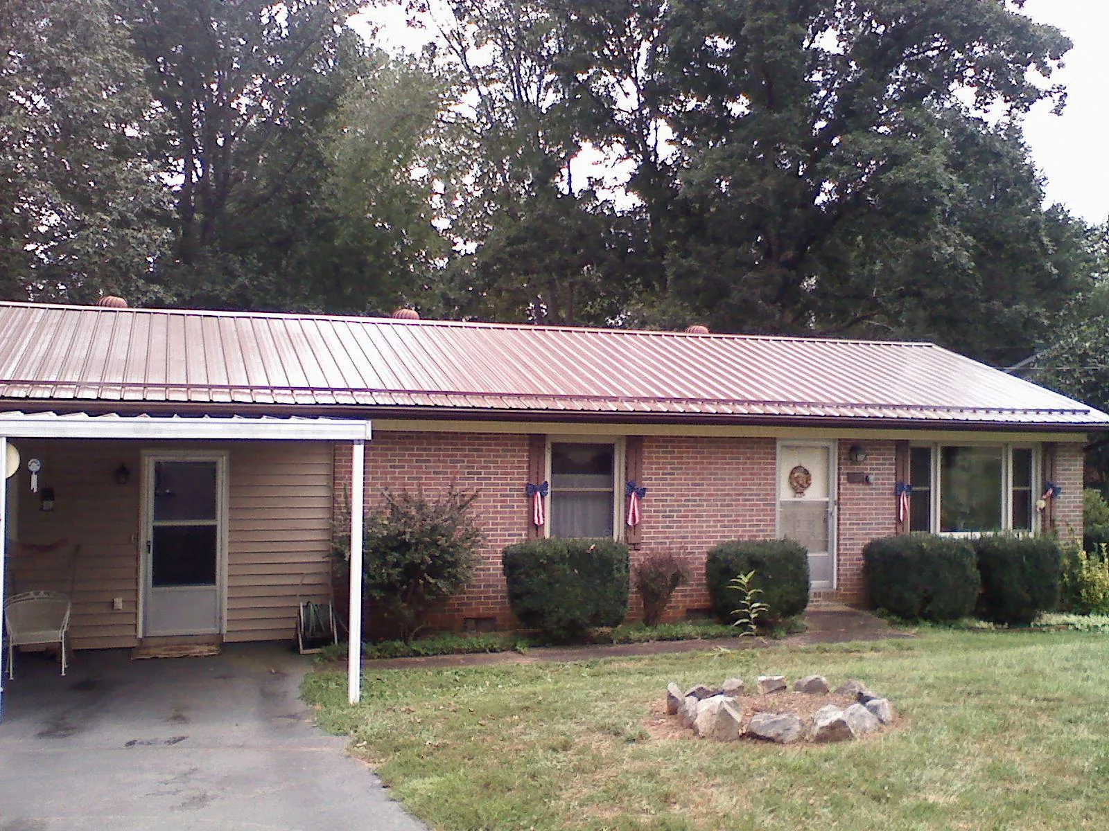 Bronze metal roof and carport on a brick ranch home — Roof Repair work by our crew in Whitesburg